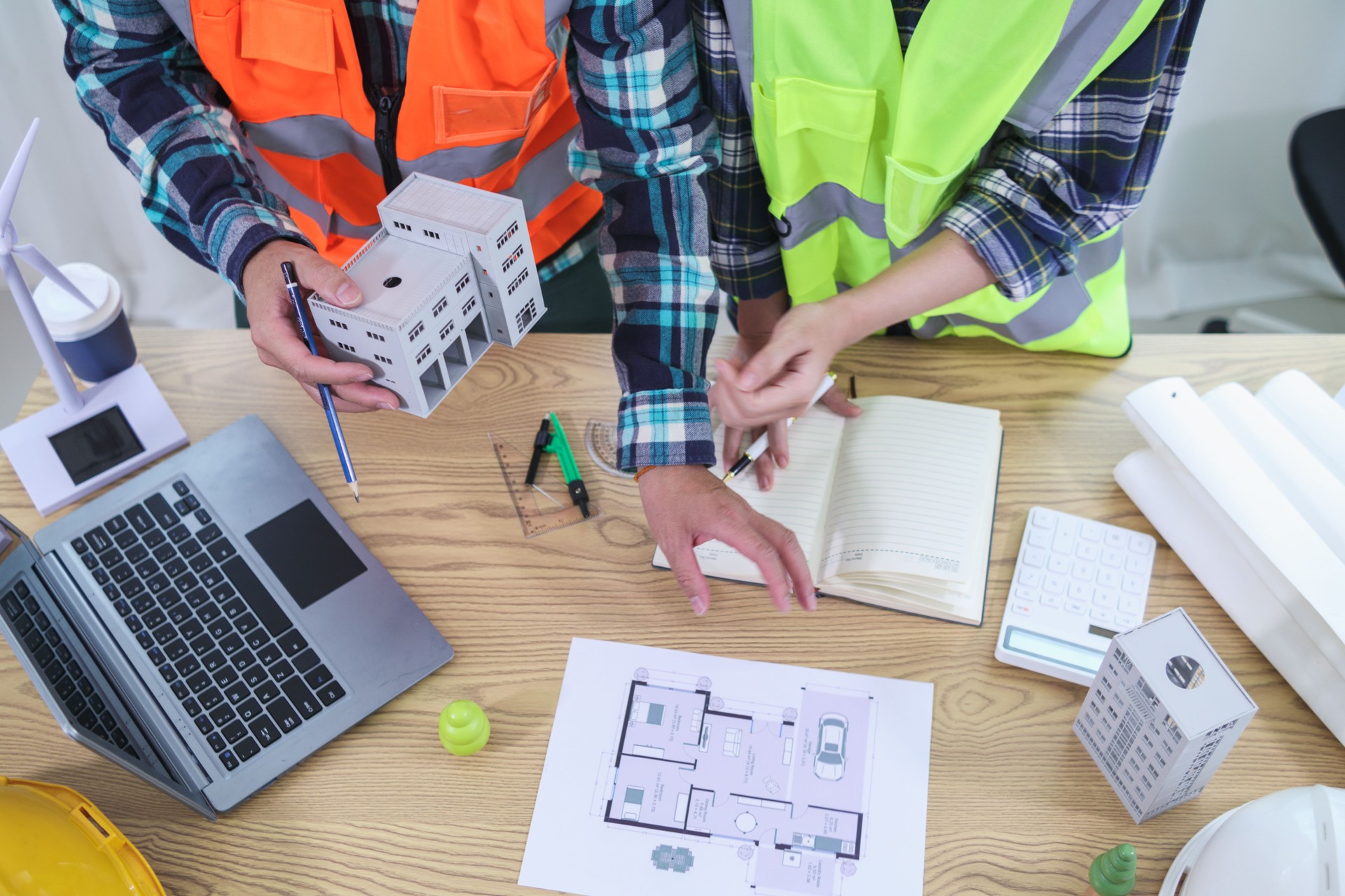 A team of engineers and architects discuss house plan design and estimate construction prices to suit the construction budget. Checking blueprints and documents with a team of engineers and architects